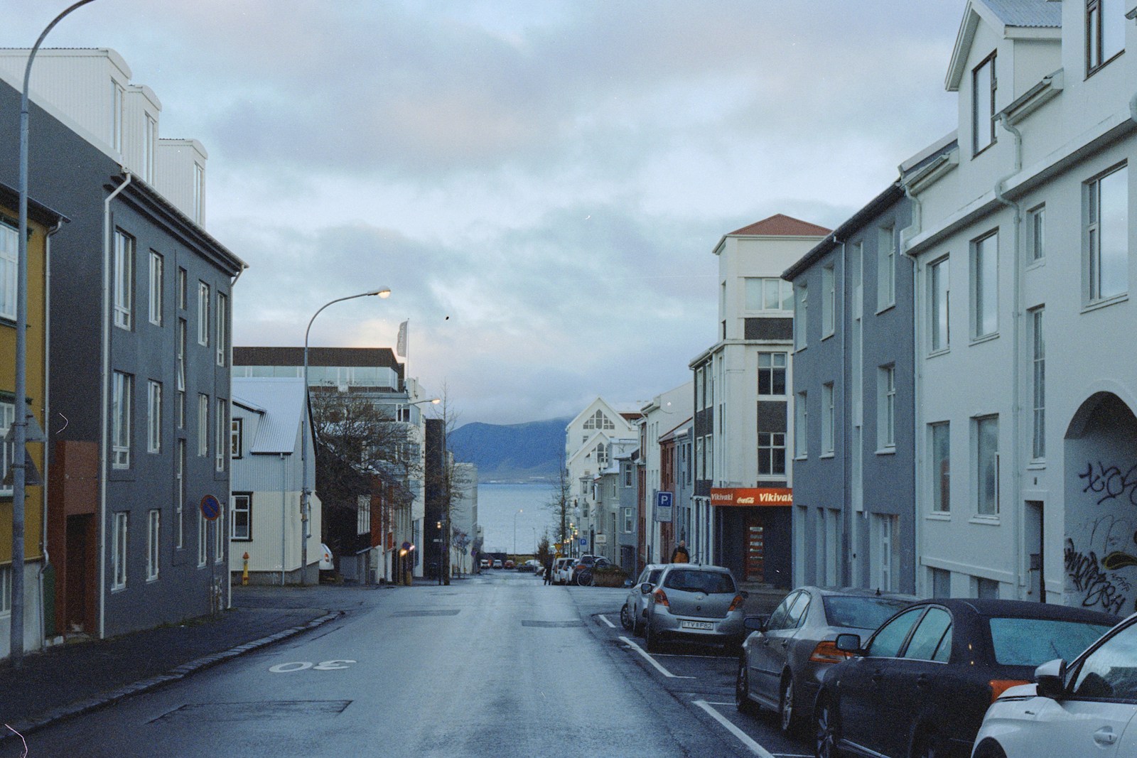 Rua residencial molhada descendo em direção ao mar em Reykjavík